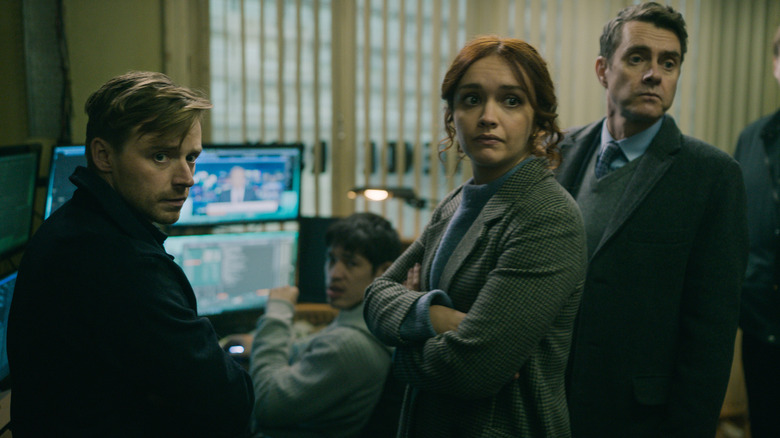 Olivia Cooke's Sid Baker, Jack Lowden's River Cartwright, Christopher Chung's Roddy Ho, and Paul Higgins' Struan Loy stand together inside Slough House in Slow Horses