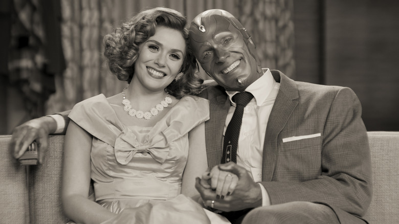 Wanda and Vision smiling on the couch together in black and white in WandaVision
