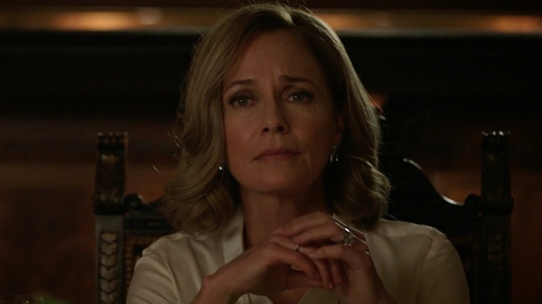 Susanna Thompson as Moira Queen, sitting at a table on Arrow