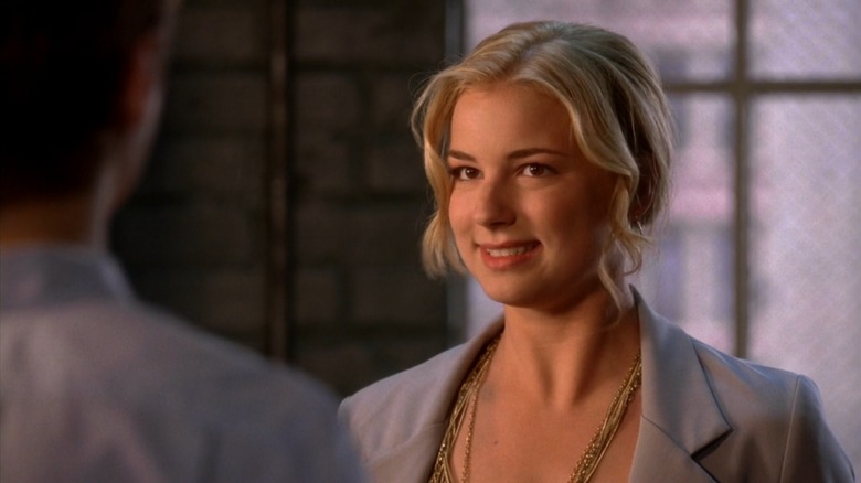Emily VanCamp as Rebecca on Brothers & Sisters, smiling uncomfortably in a grey suit
