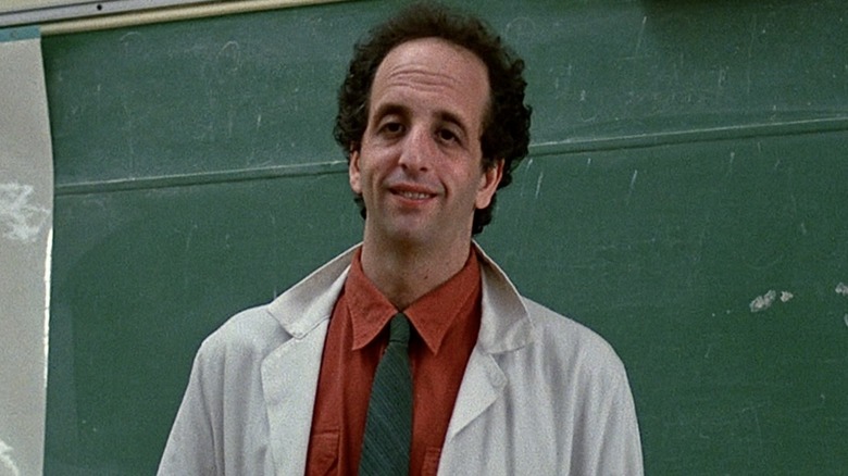 Vincent Schiavelli as Mr. Vargas smiling in front of a chalkboard in Fast Times at Ridgemont High