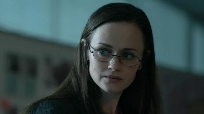 Alexis Bledel as Emily Malek, looking through glasses in The Handmaid's Tale