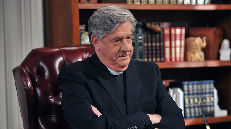 Edward Herrmann as Reverend Lowell, folding his arms in his office on How I Met Your Mother