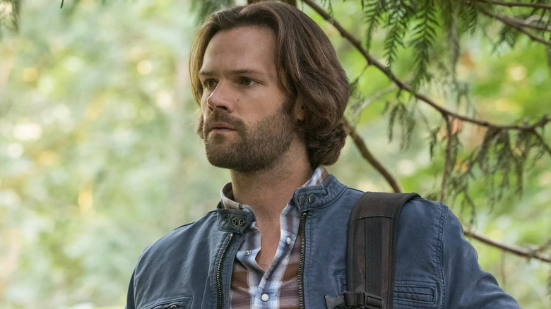 Jared Padalecki as Sam Winchester, standing in the forest in Supernatural