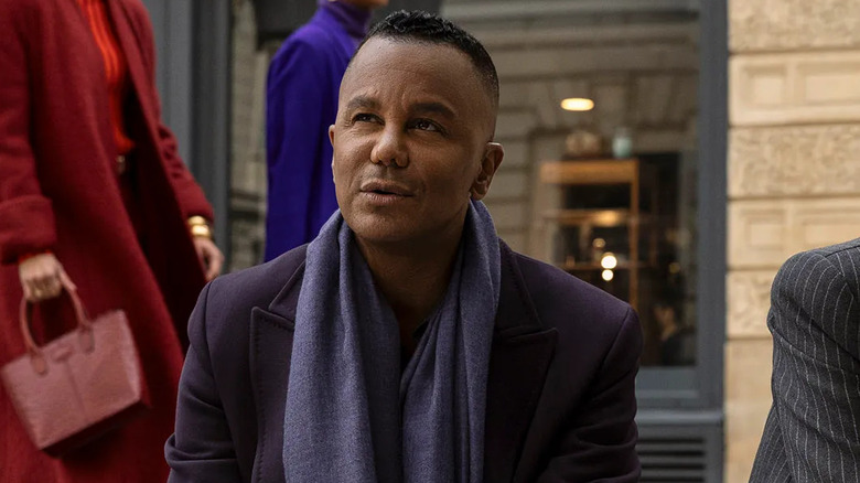 Yanic Truesdale as Raphaël Marchand, sitting on the street in Etoile