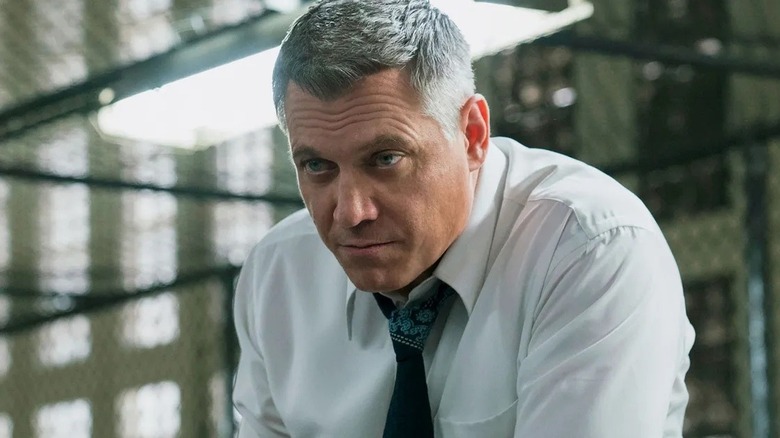 Bill leaning forward during an interrogation on Mindhunter