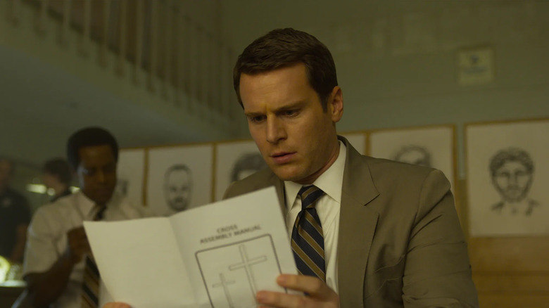 Holden reading a pamphlet on Mindhunter