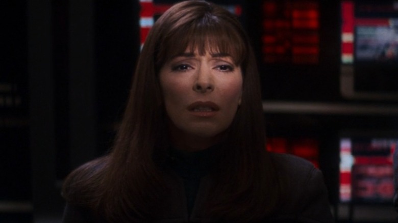 Marina Sirtis as Deanna Troi in Star Trek: Nemesis, looking upset, her eyes lit