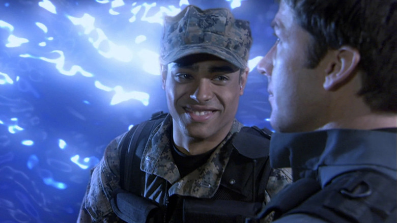 Rainbow Sun Francks as Aiden Ford, smiling in front of blue energy on Stargate Atlantis