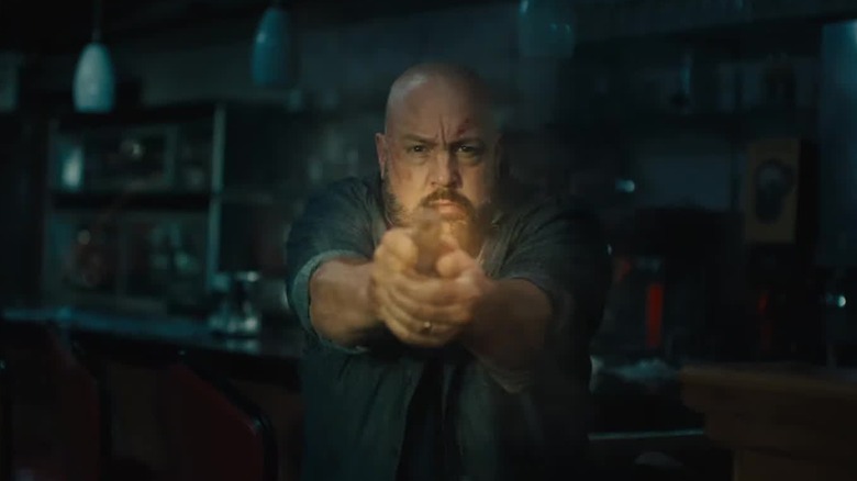 Ray Hayes (Kevin James) fires a gun in Guns Up