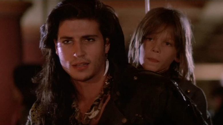 Dwayne (Billy Wirth) on motorcycle with Laddie (Chance Michael Corbitt) behind him in The Lost Boys