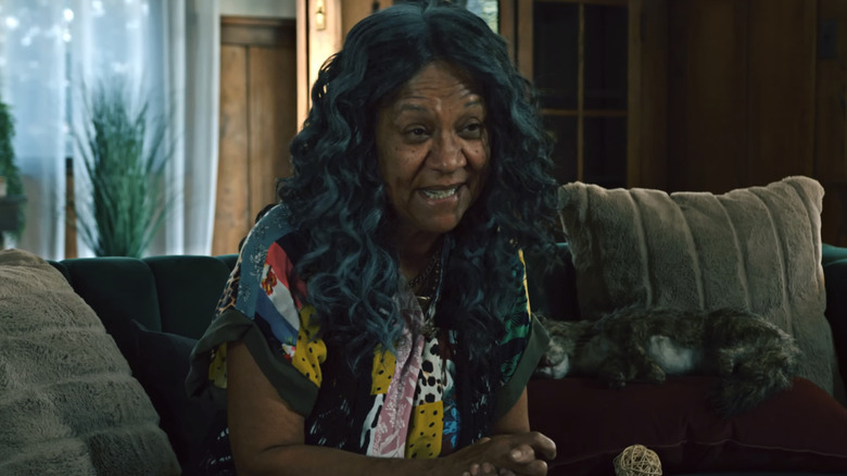 Olivia Brown as Ms. Creel, sitting on a couch with a cat in Kid Paranormal