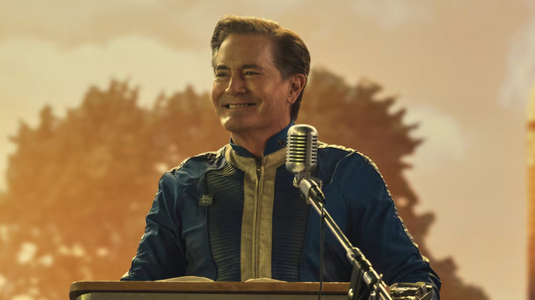 Kyle MacLachlan as Hank MacLean standing at a podium in Fallout