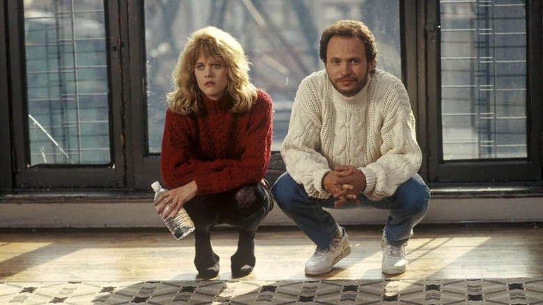 Harry and Sally squat in an empty apartment, looking unhappy in their iconic sweaters in "When Harry Met Sally..."