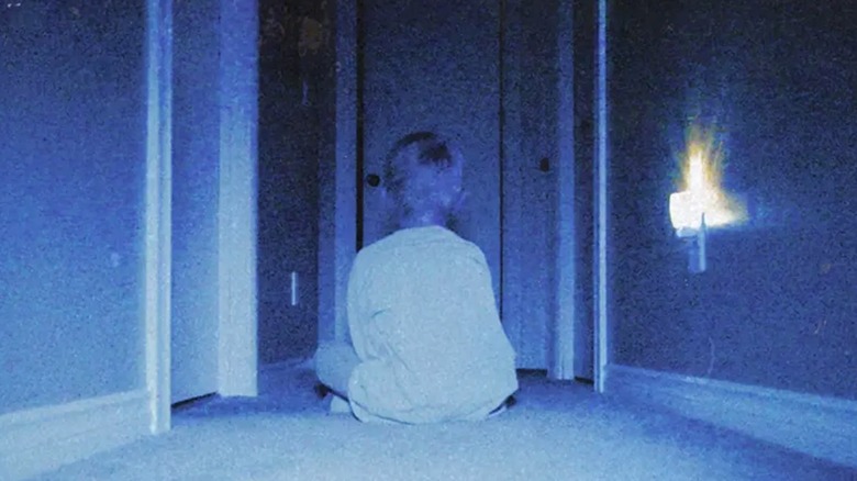 Kevin sitting in the hallway and staring at a corner in Skinamarink