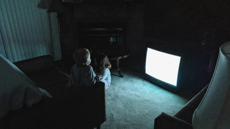 Kevin and Kaylee try to find comfort by watching TV in Skinamarink