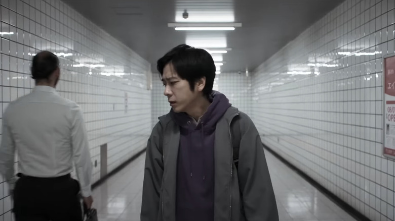 Kazunari Ninomiya's The Lost Man stands in a metro station walkway in Exit 8