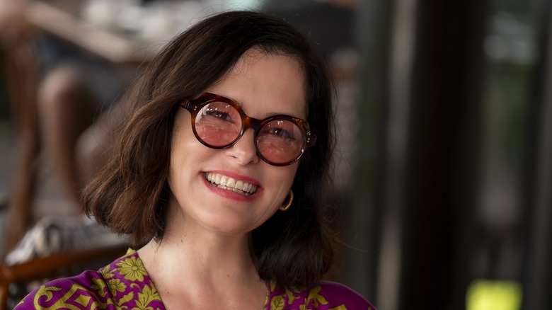Victoria in pink sunglasses grinning in The White Lotus
