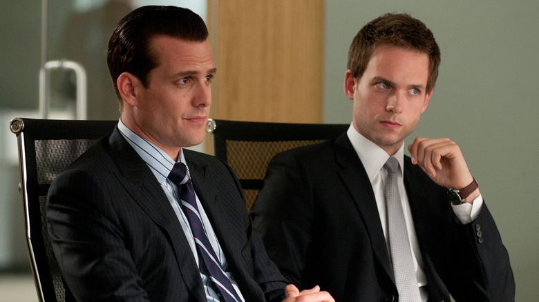 Mike and Harvey sitting at a table in the office in Suits