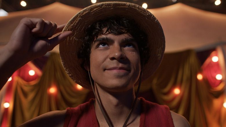 Luffy tipping his hat in respect to the former king of the pirates in One Piece