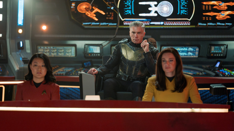 Rong Fu as Mitchell, Anson Mount as Pike, and Rebecca Romijn as Una seated on the bridge of the Enterprise in Star Trek: Strange New Worlds
