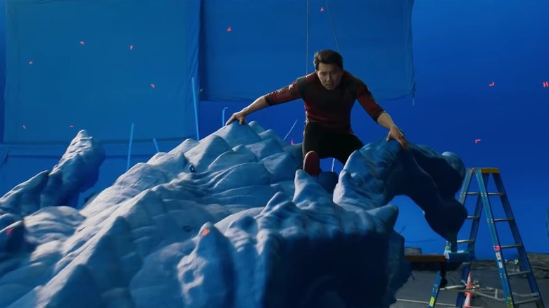 Simu Liu on a blue practical dragon rig
