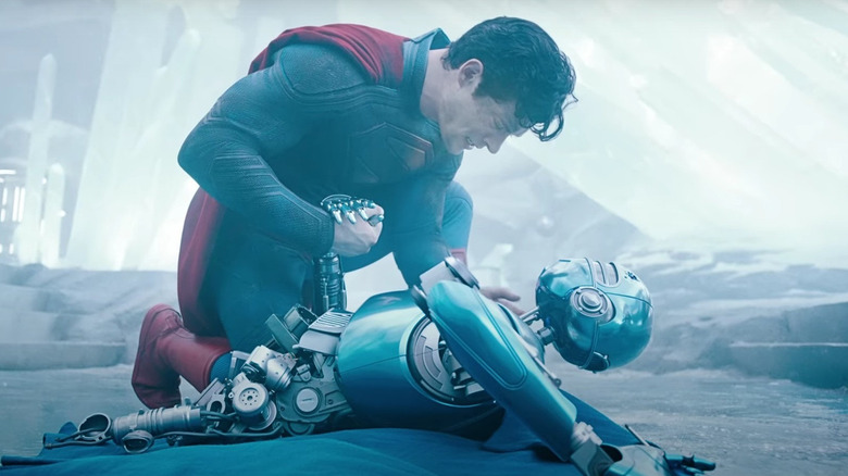 Superman kneeling over a broken robot in the Fortress of Solitude in Superman (2025)