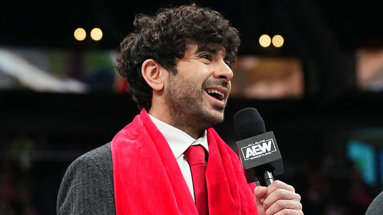 Tony Khan holding a microphone on AEW television