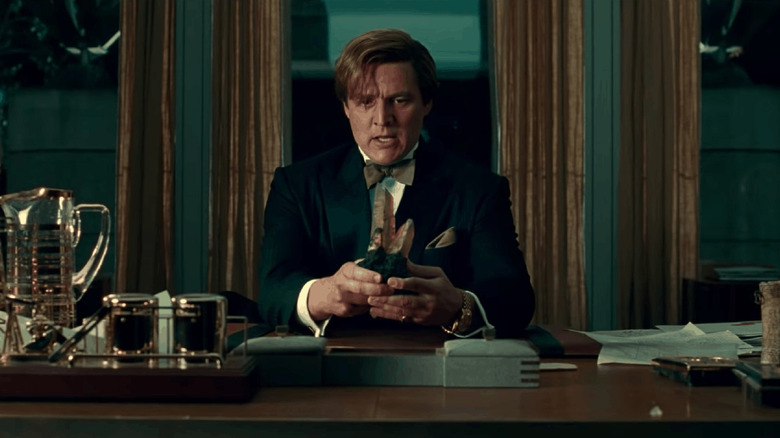 Maxwell Lorenzano carrying a magic stone on his office in Wonder Woman 1984