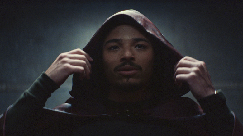 The Hood removing his hood