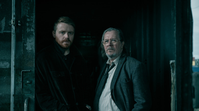 Jack Lowden's River Cartwright stands beside Gary Oldman's Jackson Lamb in a shipping container in Slow Horses