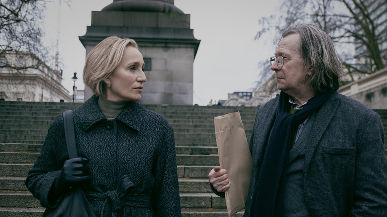 Kristin Scott Thomas' Diana Taverner stands alongside Gary Oldman's Jackson Lamb on a set of stairs in Slow Horses