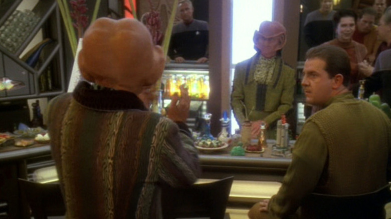 స్టార్ ట్రెక్: డీప్ స్పేస్ నైన్‌లో మార్న్ కుర్చీలో ఉన్న వ్యక్తిని చూస్తున్న క్వార్క్