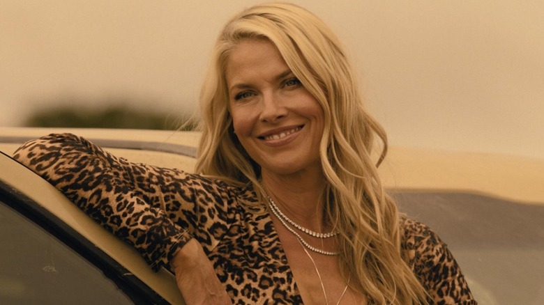 Angela Norris smiling and leaning against a car on "Landman"