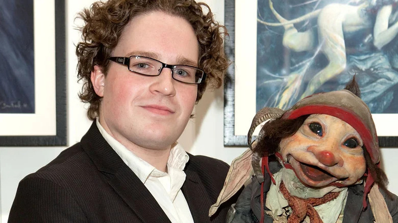 A photo of Toby Froud at a public event, holding an imp puppet.