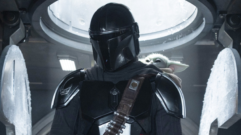 Mando in the cockpit of an AT-AT with Grogu on his back in The Mandalorian and Grogu