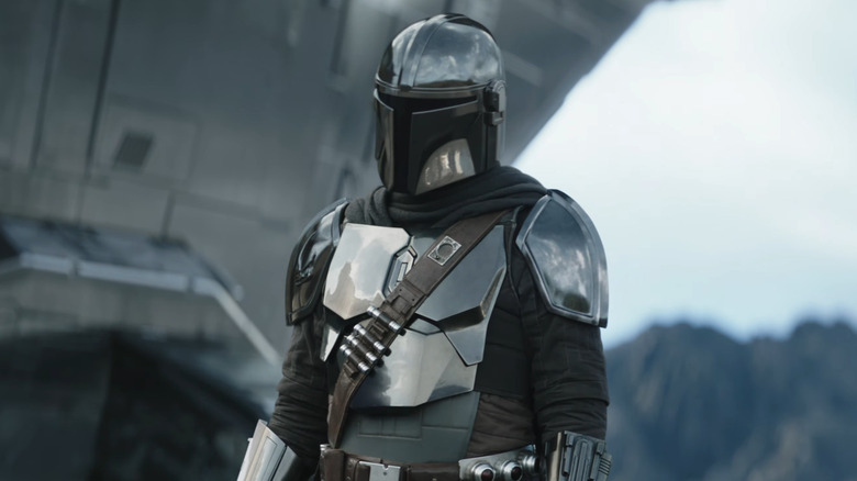 Mando standing by his new Razor Crest in The Mandalorian and Grogu