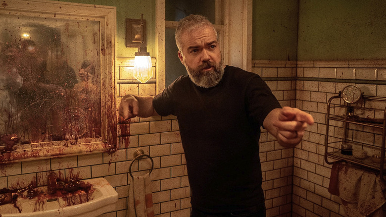 David F. Sandberg standing on the blood-covered bathroom set of Until Dawn