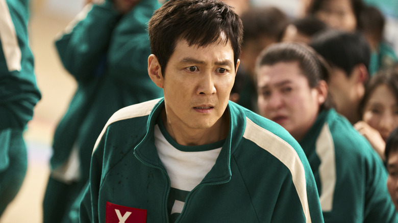 Lee Jung-jae como Seong Gi-hun com uma expressão chocada no rosto na 2ª temporada do Squid Game