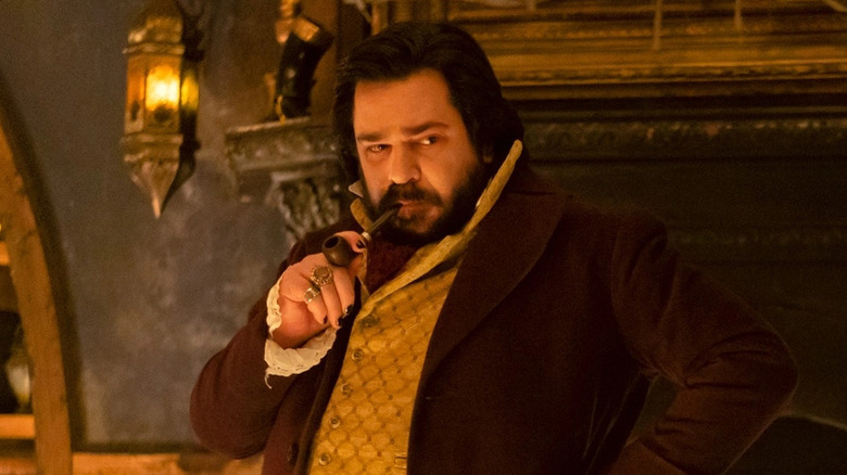 Laszlo with a pipe in his mouth in "What We Do in the Shadows"