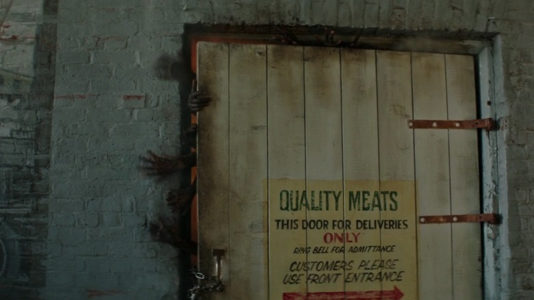 Burned hands reach through doorway