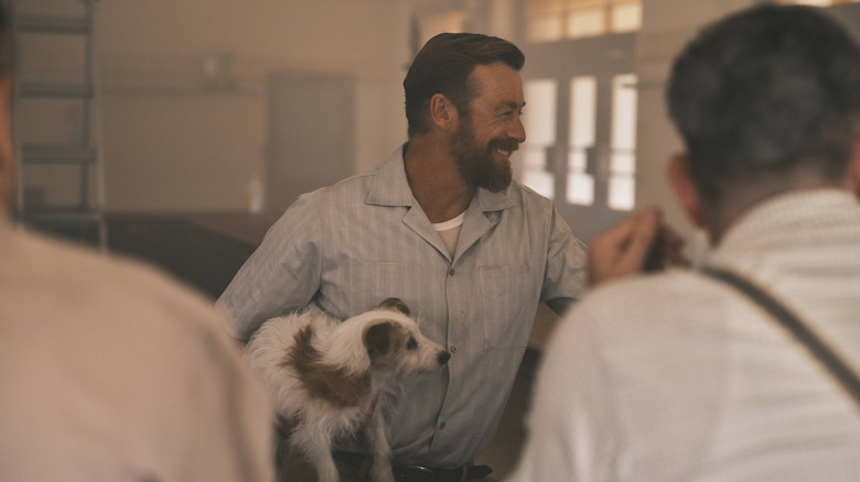 Keith Mulvaney smiling and holding a dog in The Narrow Road to the Deep North