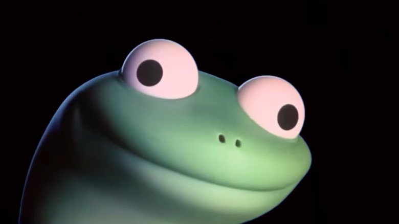 Tom the lizard's eyes look in two different directions as he has a big smile on his green face in 