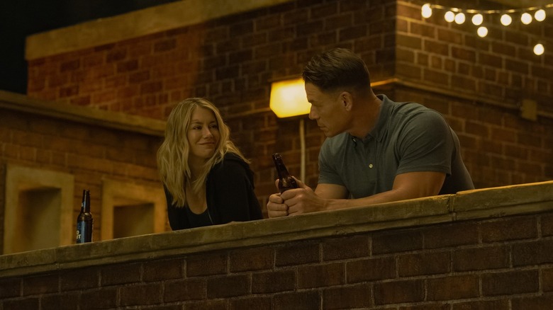 John Cena as Peacemaker and Jennifer Holland as Emilia Harcourt hanging out on the roof on Peacemaker