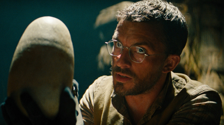 Jonathan Bailey as Dr. Henry Loomis holding a dinosaur egg in his hand in Jurassic World Rebirth