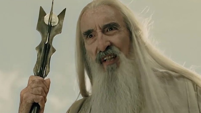 A close up of Saruman, holding his staff and with a crazed look on his face
