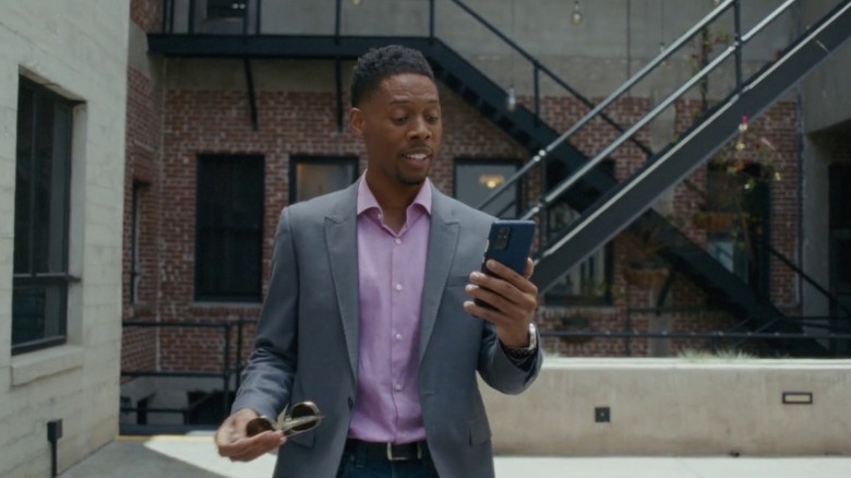 Alphonso McAuley as Devan Andrews doing a video call on his phone while walking in The Present