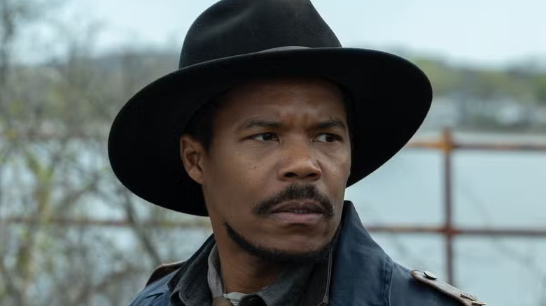 Gaius Charles as Perlie Armstrong, standing near a river in The Walking Dead: Dead City