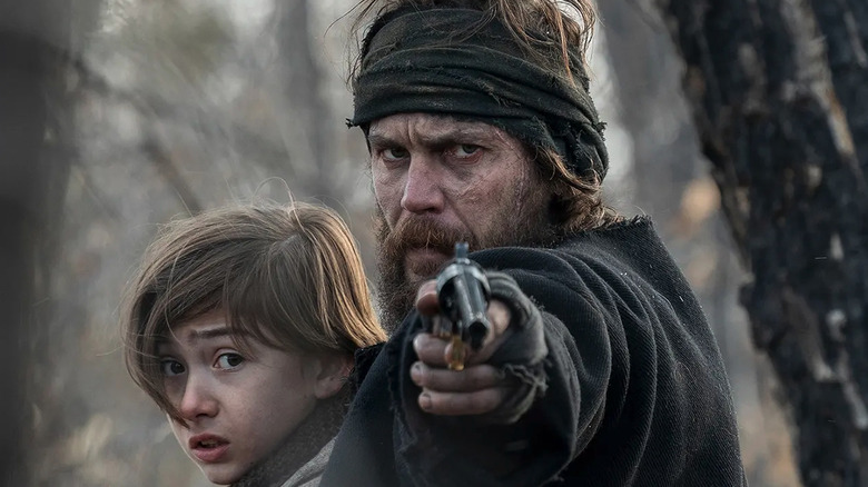 Taylor Kitsch as Isaac Reed, aiming a gun in American Primeval