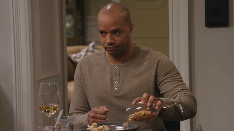 Donald Faison as Trey Taylor, pouring nuts out of a glass on Extended Family